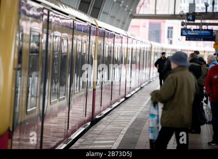 13 marzo 2020, Berlino: I passanti si trovano alla stazione della S-Bahn in arrivo ad Alexanderplatz. Il treno registra attualmente meno passeggeri del solito. Foto: Kay Nietfeld/Dpa Foto Stock