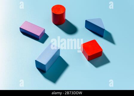 Sfondo blu con figure geometriche rosse che proiettano ombre in una composizione semplice. Foto Stock
