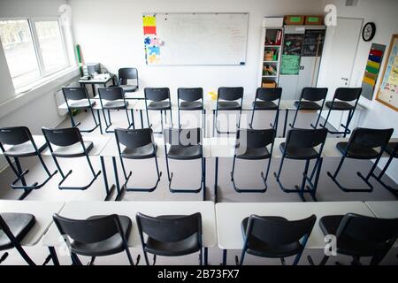 13 marzo 2020, Renania Settentrionale-Vestfalia, Übach-Palenberg: Le sedie si trovano sui tavoli in un'aula vuota del Carolus-Magnus-Gymnasium. Nel quartiere di Heinsberg le scuole e gli asili rimarranno chiusi per un'altra settimana, perspectivamente fino alle vacanze di Pasqua. Foto: Jonas Güttler/Dpa Foto Stock