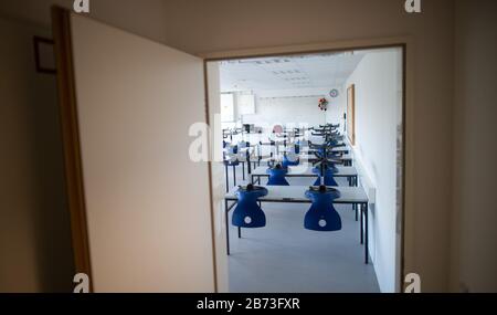 13 marzo 2020, Renania Settentrionale-Vestfalia, Übach-Palenberg: Le sedie si trovano sui tavoli in un'aula vuota del Carolus-Magnus-Gymnasium. Nel quartiere di Heinsberg le scuole e gli asili rimarranno chiusi per un'altra settimana, perspectivamente fino alle vacanze di Pasqua. Foto: Jonas Güttler/Dpa Foto Stock