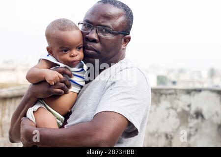 L'uomo di mezza età scatta una foto con il suo bambino mentre guarda la macchina fotografica. Foto Stock