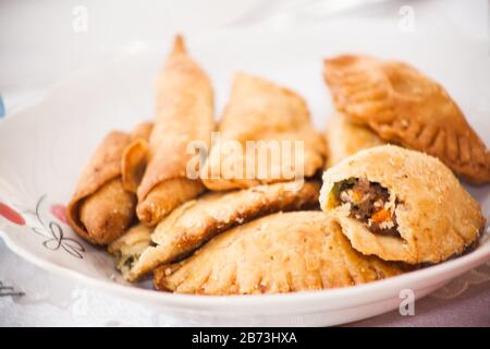 Deliziose torte di carne fatte in casa servite su un piatto. Forno, croccante e dorato. Infuso con carne macinata e verdure tagliate a dadini. molto gustoso e. Foto Stock