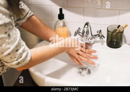 Mani lavate. Le mani si lavano sotto l'acqua corrente con la tecnica corretta e sapone antibatterico in bagno. Prevenire l'epidemia di coronavirus. Prevenzione di Foto Stock