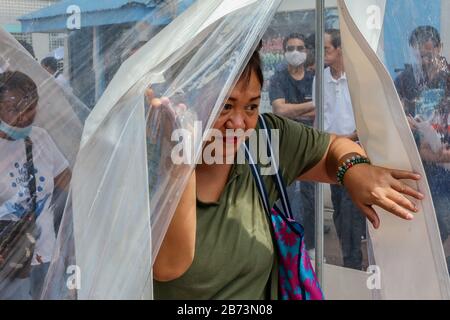 Marikina City, Filippine. 13 Marzo 2020. Un residente prova una tenda di decontaminazione durante una dimostrazione di disinfezione a Marikina City, Filippine, 13 marzo 2020. Il presidente filippino Rodrigo Duterte ha posto l'intera Metro Manila sotto 'quarantena comunitaria' dopo aver innalzato il livello di allarme per la salute pubblica al livello più alto del Codice Rosso sub-livello 2, in una drastica iniziativa di fermare la diffusione del coronavirus. Le Filippine hanno ora 52 casi confermati di COVID-19, di cui cinque morti. Credit: Rouelle Umali/Xinhua/Alamy Live News Foto Stock