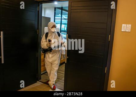 Marikina City, Filippine. 13 Marzo 2020. Un lavoratore in tuta protettiva disinfetta gli uffici del municipio a Marikina City, Filippine, 13 marzo 2020. Il presidente filippino Rodrigo Duterte ha posto l'intera Metro Manila sotto 'quarantena comunitaria' dopo aver innalzato il livello di allarme per la salute pubblica al livello più alto del Codice Rosso sub-livello 2, in una drastica iniziativa di fermare la diffusione del coronavirus. Le Filippine hanno ora 52 casi confermati di COVID-19, di cui cinque morti. Credit: Rouelle Umali/Xinhua/Alamy Live News Foto Stock