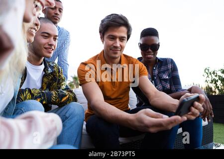 Gruppo di amici di corse miste insieme durante una giornata di sole Foto Stock