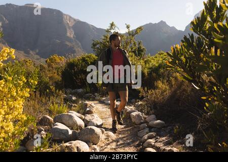 Vista frontale dell'uomo con uno zaino a piedi su un sentiero Foto Stock