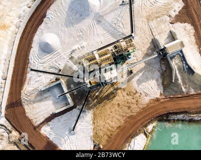 Vista aerea dello stabilimento di trasformazione con la colonna di frazionamento di sabbia in corrispondenza di un bordo di una sabbia di quarzo stagno di cava per il bianco sabbia di quarzo, realizzata con drone Foto Stock