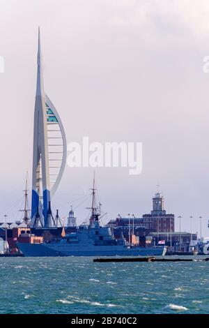 Nave da guerra lungo il porto navale di Portsmouth con la torre Spinnaker sullo sfondo Foto Stock