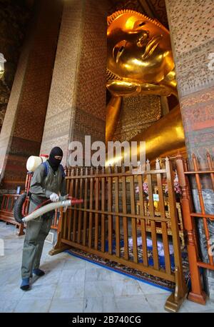 Bangkok, Thailandia. 13 Marzo 2020. Disinfettante spray ufficiale tailandese accanto ad una grande statua di Buddha reclinabile come precauzione contro lo scoppio del Coronavirus Covid-19 a Wat Pho a Bangkok il 13 marzo 2020. La malattia virale del COVID-19 che ha travolti in almeno 114 paesi e ucciso più di 4,000 persone è ora ufficialmente una pandemia, ha annunciato l'Organizzazione Mondiale della Sanità. Credit: Urdee Image/Zuma Wire/Alamy Live News Foto Stock