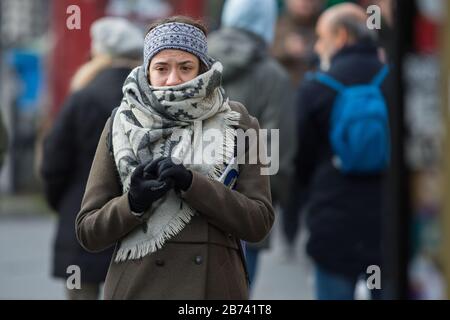 Edimburgo, Regno Unito. 13 Marzo 2020. Nella foto: Le persone hanno visto indossare maschere e coprire il naso e la bocca con le sciarpe a causa della pandemia di Coronavirus. Credit: Colin Fisher/Alamy Live News Foto Stock