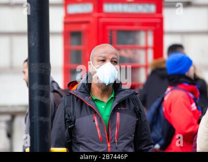 Londra, Regno Unito. 13 Marzo 2020. Un uomo che indossa una maschera nel centro di Londra. La paura di Coronavirus sta crescendo man mano che il numero di casi aumenta rapidamente ogni giorno. Credit: Tommy London/Alamy Live News Foto Stock