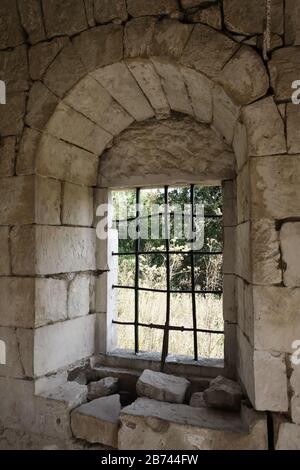 Frammento interno della Chiesa abbandonata, muro di pietra bianca con finestra vuota Foto Stock