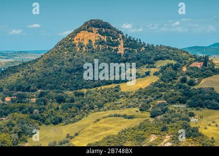 Monte Voltraio, una collina con pendici ricoperte da boschi circondata da prati vicino a Roncolla fuori da una cittadina collinare di Volterra in Toscana. Foto Stock