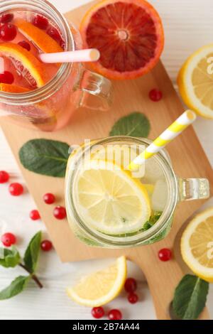 Vasetti di vetro con limonata su sfondo di legno. Bevanda fresca Foto Stock