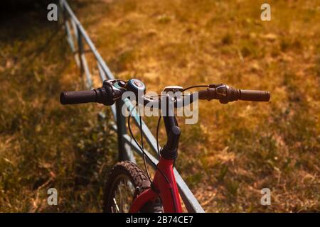 Manubrio per bicicletta al tramonto su un prato Foto Stock