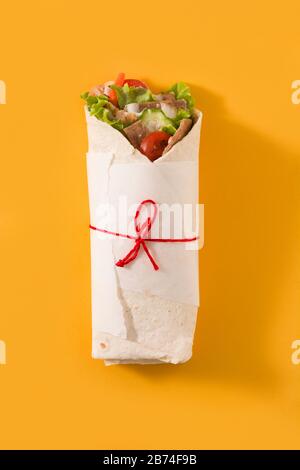 Doner kebab o shawarma sandwich isolato su sfondo giallo Foto Stock