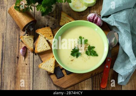 Il concetto di cibo sano e dietetico, piatto vegetariano. Deliziosa zuppa di verdure con panna e zucchine su un tavolo rustico. Spazio di copia. Foto Stock