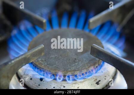 Primo piano immagine della fiamma di gas che brucia su un piano cottura domestico della cucina. Problema di riscaldamento globale.aumento dei prezzi dell'energia nel Regno Unito.Fossil Fuels.cambiamento climatico. Foto Stock