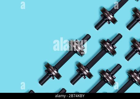 Immagini sportive. Manubri su sfondo blu. Disposizione piatta, vista dall'alto, spazio copia. Foto Stock