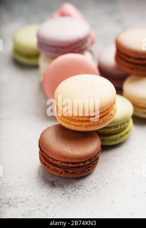 I biscotti francesi di maccheroni di colori diversi sono sul tavolo grigio. Ancora vita di pasticceria. Primo piano Foto Stock