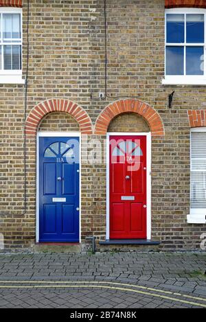 Due porte anteriori identiche, una rossa e blu, su vecchie case a schiera su Brocas Street, Eton Berkshire England UK Foto Stock