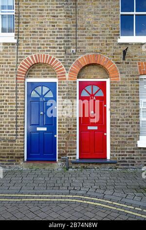 Due porte anteriori identiche, una rossa e blu, su vecchie case a schiera su Brocas Street, Eton Berkshire England UK Foto Stock