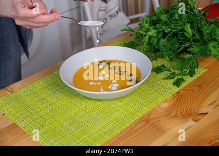 Preparazione di brodo di pollo con verdure bouillon in una pentola. Lavagna nera come sfondo. Cucina da lavoro scenario da sopra. Foto Stock
