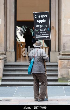 Apple Store Glasgow con uomo fuori porta cartello pubblicità più economici Apple riparazioni nelle vicinanze - Glasgow, Scozia, Regno Unito Foto Stock