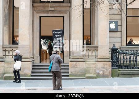 Apple Store Glasgow con uomo fuori porta cartello pubblicità più economici Apple riparazioni nelle vicinanze - Glasgow, Scozia, Regno Unito Foto Stock