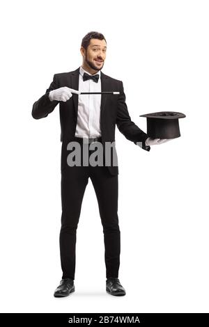 Ritratto a tutta lunghezza di un mago con bacchetta magica e cappello isolato su sfondo bianco Foto Stock