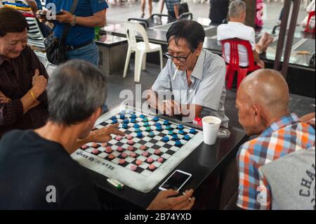 10.01.2020, Singapore, Repubblica di Singapore, Asia - gli uomini giocano a scacchi cinesi, chiamati anche Xiangqi, sulla Piazza dell'Ayer di Creta a Chinatown. Spesso, sono coinvolti importi di denaro più piccoli. [traduzione automatica] Foto Stock