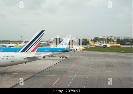 06.12.2019, Singapore, Repubblica di Singapore, Asia - due aerei passeggeri di Air France e KLM di tipo Boeing 777-300 ER sono parcheggiati all'Aeroporto di Changi. Entrambe le compagnie aeree sono membri dell'alleanza SkyTeam. Sullo sfondo è possibile vedere gli aerei della linea aerea di bilancio Scoot. [traduzione automatica] Foto Stock