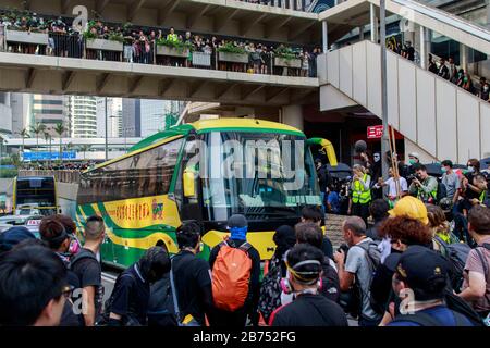 I manifestanti bloccano un autobus dalla Cina nel distretto centrale durante una parata. I manifestanti si scontrano violentemente con la polizia anti-sommossa di Hong Kong durante il 70° anniversario della Cina. Foto Stock