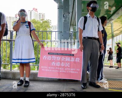 Quattro studenti delle scuole secondarie formano una catena umana per sostenere uno studente arrestato dalla polizia il 3 settembre 2019. Foto Stock