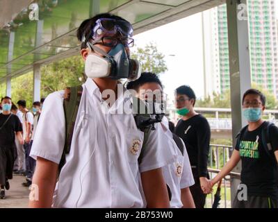 Quattro studenti delle scuole secondarie formano una catena umana per sostenere uno studente arrestato dalla polizia il 3 settembre 2019. Foto Stock