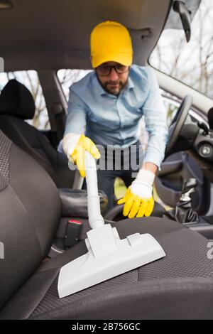 Maschio che utilizza un aspirapolvere a vapore professionale per gli  interni sporchi dell'auto. Concetto professionale di servizio di pulizia  auto Foto stock - Alamy