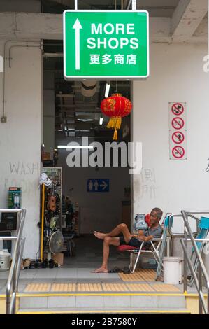 24.02.2019, Singapore, Repubblica di Singapore, Asia - un anziano siede su una sedia nel quartiere di Chinatown di Singapore e riposa. [traduzione automatica] Foto Stock