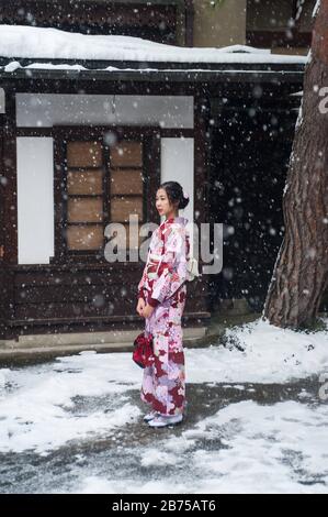 27.12.2017, Takayama, Giappone, Asia - UNA giovane donna giapponese in kimono tradizionale sta in piedi in una strada mentre sta nevicando. [traduzione automatica] Foto Stock