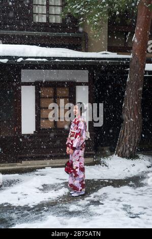 27.12.2017, Takayama, Giappone, Asia - UNA giovane donna giapponese in kimono tradizionale sta in piedi in una strada mentre sta nevicando. [traduzione automatica] Foto Stock