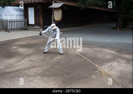 31.12.2017, Tokyo, Giappone, Asia - UN lavoratore del tempio spazza i terreni del Santuario Meiji di Shibuya con una scopa. [traduzione automatica] Foto Stock