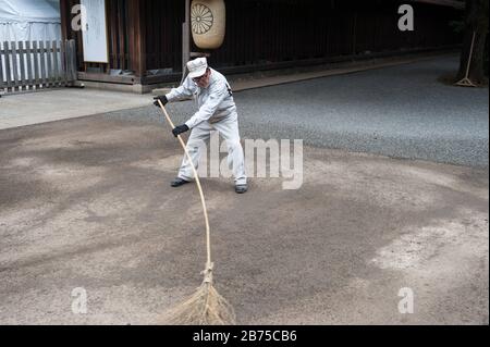 31.12.2017, Tokyo, Giappone, Asia - UN lavoratore del tempio spazza i terreni del Santuario Meiji di Shibuya con una scopa. [traduzione automatica] Foto Stock