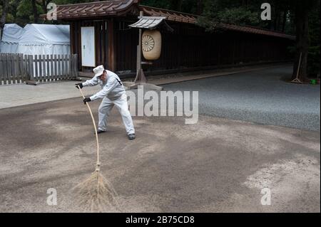 31.12.2017, Tokyo, Giappone, Asia - UN lavoratore del tempio spazza i terreni del Santuario Meiji di Shibuya con una scopa. [traduzione automatica] Foto Stock