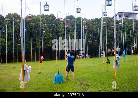 02.12.2018, Singapore, Repubblica di Singapore, Asia - un amante degli uccelli appende uno dei suoi birdgages su un flagpole al Kebun Baru Bird Corner in Ang Mo Kio Town Garden West. [traduzione automatica] Foto Stock