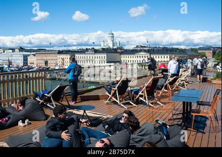 23.06.2018 - Helsinki, Finlandia, Europa - la gente prende il sole sulla terrazza sul tetto della piscina sul mare di Allas. Sullo sfondo potrete vedere la Piazza del mercato, il Palazzo Presidenziale e la Cattedrale di Helsinki. [traduzione automatica] Foto Stock