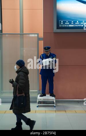 23.12.2017, Osaka, Giappone, Asia - UN dipendente aeroportuale in uniforme si trova su una piccola piattaforma all'Aeroporto Internazionale di Kansai e prende appunti. [traduzione automatica] Foto Stock