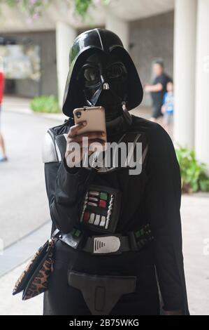 06.05.2017, Singapore, Repubblica di Singapore, Asia - UNA donna in un costume di Darth Vader sta usando il suo smartphone durante l'evento annuale di Star Wars nel boschetto dei Supertrees a Gardens by the Bay. [traduzione automatica] Foto Stock