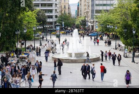 Vista della trafficata Piazza Syntagma con una fontana nel mezzo di Atene il 11.04.2016. A Piazza Syntagma si trova il Parlamento greco e, dall'altro lato, una famosa strada dello shopping. [traduzione automatica] Foto Stock