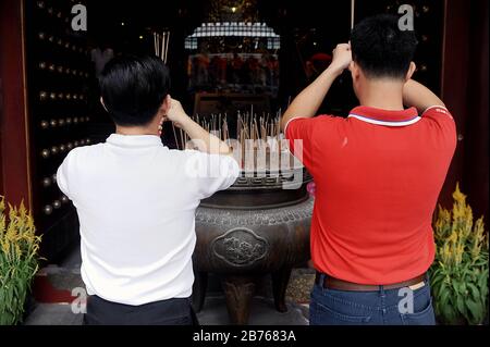 SINGAPORE, 19 febbraio 2015 - due uomini pregano all'ingresso del Tempio Reliquico del dente di Buddha nella Chinatown di Singapore il primo giorno delle celebrazioni di più giorni per il Capodanno cinese. Il nuovo anno si basa sul calendario lunare cinese ed è sotto il segno della pecora o della capra. Il tempio è uno dei numerosi luoghi di interesse della città-stato, tre quarti della cui popolazione è composta da persone di origine cinese. [traduzione automatica] Foto Stock