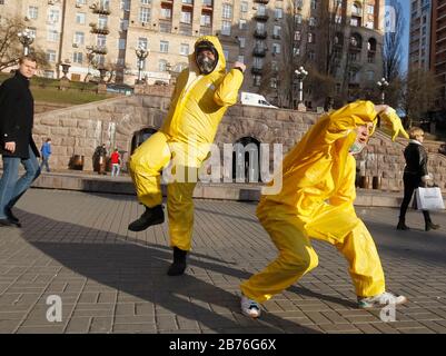 Kiev, Ucraina. 13 Marzo 2020. Le persone che indossano costumi protettivi ballano mentre prendono parte a un flashmob contro il coronavirus COVID-19 in una strada nel centro di Kiev, Ucraina, il 13 marzo 2020. L'Ucraina chiuderà il confine per gli stranieri in 48 ore per due settimane a causa della situazione con il coronavirus COVID-19 diffuso nel mondo, il Segretario del Consiglio Nazionale di sicurezza e Difesa dell'Ucraina Oleksiy Danilov ha detto il 13 marzo 2020. Credit: Serg Glovny/Zuma Wire/Alamy Live News Foto Stock